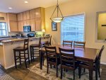 Large dining table with seating for 6, plus 3 stools at the breakfast bar.